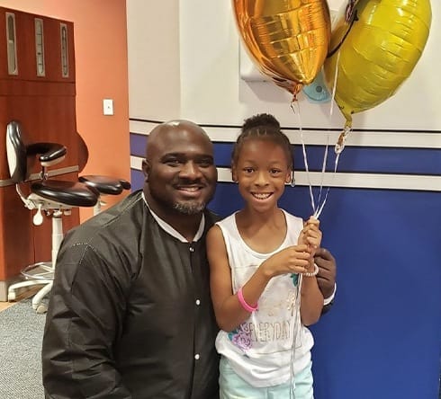 Doctor Marable and young patient with balloons after dental checkup