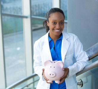 Fort Valley cosmetic dentist smiling and holding piggy bank
