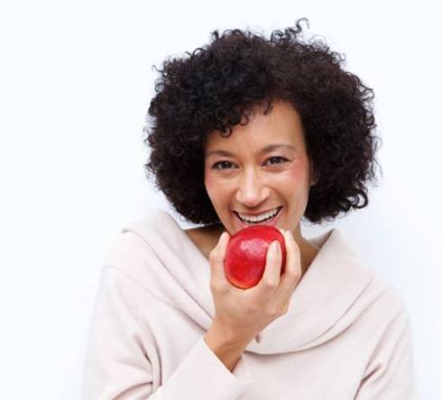 woman biting into a red apple 