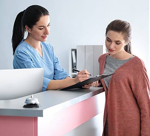 dental assistant explaining the cost of dental implants in Fort Valley to a patient