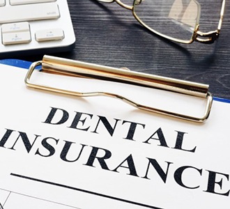 dental insurance form on a blue clipboard