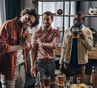 man opening bottle with mouth at party 