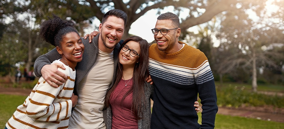 Four people sharing healthy smiles after dental services