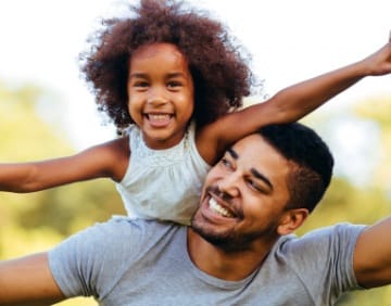 Father and daughter smiling after children's dentistry visit