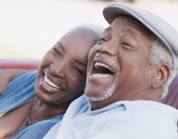 Man and woman smiling after replacing missing teeth