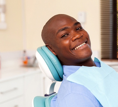 Man in blue shirt waiting on dental chair