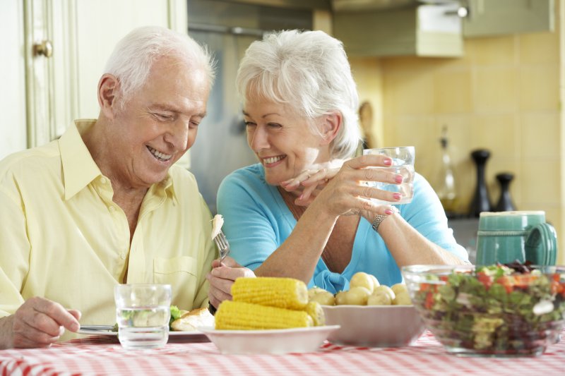 Couple smiling at table filled with summer foods