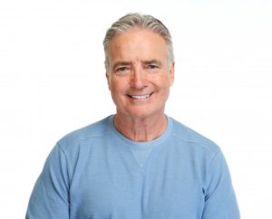 Man smiling with blue shirt and white background