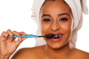 Woman brushing her teeth with charcoal