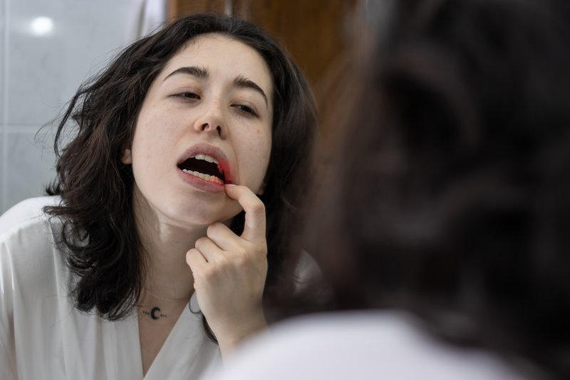 Patient checking for gum disease in bathroom mirror